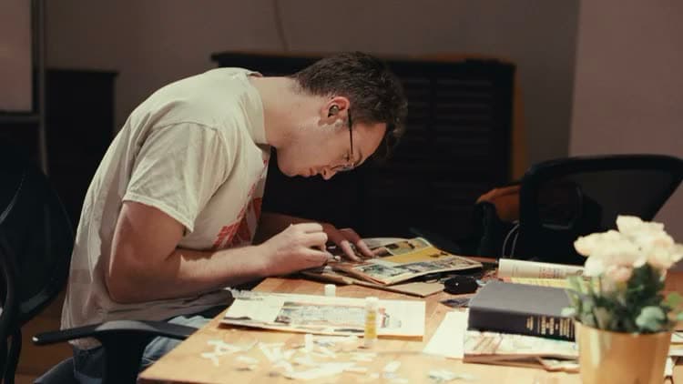 A writer working at a desk covered in notes