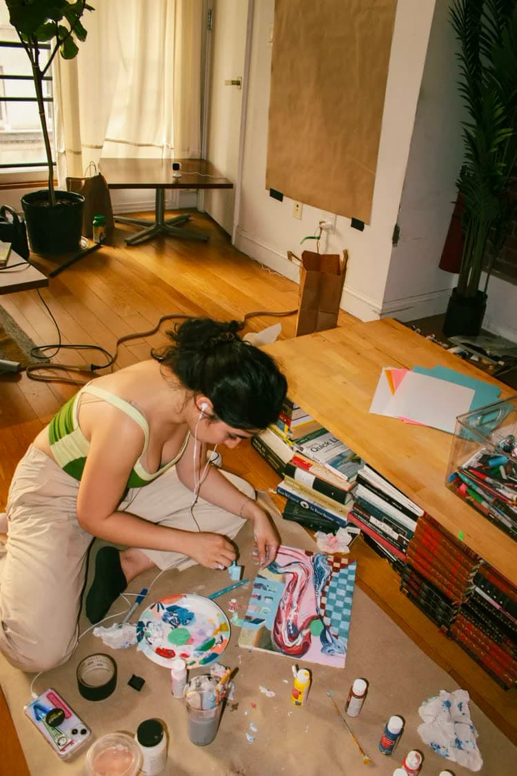 A painter working on a canvas on the floor